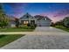 Well-manicured home with paver driveway, lush landscaping, and inviting front porch, showcasing curb appeal at 5971 Hidden Branch Dr, Apollo Beach, FL 33572