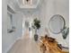 Bright hallway with light wood floors, decorative accents, and a staircase leading to the upper level at 5971 Hidden Branch Dr, Apollo Beach, FL 33572