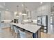 Modern kitchen with an island, stainless steel appliances, and white cabinets with elegant pendant lighting at 5971 Hidden Branch Dr, Apollo Beach, FL 33572