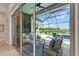 The lanai with outdoor seating overlooking the pool, pond and green grass at 5971 Hidden Branch Dr, Apollo Beach, FL 33572