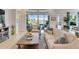 Open living room features large windows with scenic outdoor view, light wood flooring, and neutral furniture at 5971 Hidden Branch Dr, Apollo Beach, FL 33572