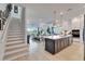 Bright, open-concept living space with a modern kitchen island and elegant staircase at 5971 Hidden Branch Dr, Apollo Beach, FL 33572