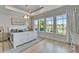 Bright main bedroom with tray ceiling, large windows, and views of the lake at 5971 Hidden Branch Dr, Apollo Beach, FL 33572