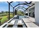 Luxurious pool with sun loungers inside a screened enclosure, offering relaxation and stunning natural views at 5971 Hidden Branch Dr, Apollo Beach, FL 33572