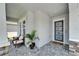 Inviting covered front porch with comfortable seating and a view of the home's contemporary front door at 5971 Hidden Branch Dr, Apollo Beach, FL 33572