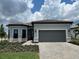 Charming single-story home featuring a tile roof, paver driveway, and gray exterior paint at 6162 Winding Pine Dr, Nokomis, FL 34275