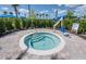 Inviting hot tub with a chair lift surrounded by manicured hedges and a paved patio at 6162 Winding Pine Dr, Nokomis, FL 34275