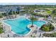 Lagoon-style pool with ample seating, surrounded by lush palm trees in the community at 6162 Winding Pine Dr, Nokomis, FL 34275