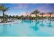 Resort-style pool featuring a tranquil waterfall, comfortable lounge chairs, and lush tropical landscaping at 6162 Winding Pine Dr, Nokomis, FL 34275