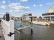 Waterfront property featuring a boat lift in a canal and views of neighboring homes at 6531 Seaview Blvd, Hudson, FL 34667