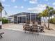 View of the back of the home featuring a screened in patio with furniture and tropical landscaping at 6531 Seaview Blvd, Hudson, FL 34667