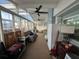 Spacious sunroom featuring multiple ceiling fans, tile flooring, and various seating areas at 6531 Seaview Blvd, Hudson, FL 34667
