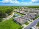 Aerial view of a well-maintained neighborhood featuring cozy homes and lush green spaces surrounding a pond at 6606 Pullen Ct, Tampa, FL 33625