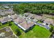 Overhead view of residences in a community featuring mature trees, landscaped lawns, and a pond at 6606 Pullen Ct, Tampa, FL 33625