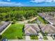 Aerial view of a well-maintained home with a lush green lawn, a pond, and mature trees creating a peaceful setting at 6606 Pullen Ct, Tampa, FL 33625