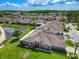 Aerial view of a well-maintained home with a large, green yard next to a small pond at 6606 Pullen Ct, Tampa, FL 33625