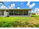The backyard provides a great view of the screened-in lanai and green lawn at 6606 Pullen Ct, Tampa, FL 33625