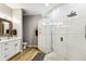 Bathroom with sleek shower, white cabinets, wood tile floor at 6606 Pullen Ct, Tampa, FL 33625