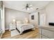 Cozy bedroom featuring a ceiling fan, white furnishings and wood-look flooring at 6606 Pullen Ct, Tampa, FL 33625