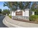 Community sign with stone accents, landscaping, and a well-paved road at 6606 Pullen Ct, Tampa, FL 33625