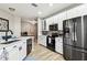 Bright kitchen features stainless steel appliances, white cabinets, and a black sink and faucet at 6606 Pullen Ct, Tampa, FL 33625