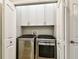 Convenient laundry room with modern washer and dryer units, and built-in white storage cabinets at 6606 Pullen Ct, Tampa, FL 33625