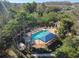 Aerial perspective of the community pool complete with tables, lounge chairs, mature landscaping and a pool house at 6606 Pullen Ct, Tampa, FL 33625