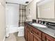 Well-lit bathroom featuring a shower with a striped curtain, a dark vanity, and neutral paint at 700 Beach Ne Dr # 602, St Petersburg, FL 33701