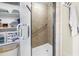 Modern bathroom with a tiled shower, glass door, and chrome fixtures, adjacent to a storage area with shelving at 700 Beach Ne Dr # 602, St Petersburg, FL 33701