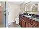 Bathroom featuring cherry wood cabinets, dark countertops, updated fixtures, and a modern glass-enclosed shower at 700 Beach Ne Dr # 602, St Petersburg, FL 33701