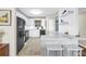 Open kitchen with white cabinetry, marble countertops, and breakfast bar, seamlessly connects to the dining area at 700 Beach Ne Dr # 602, St Petersburg, FL 33701