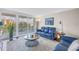 A bright living room with a blue sofa and floor to ceiling window offering beautiful views from the home at 700 Beach Ne Dr # 602, St Petersburg, FL 33701