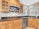 Detailed view of modern microwave, sink, dishwasher, and granite countertops in a warm kitchen at 708 E Patterson St, Tampa, FL 33604
