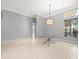 Bright dining room features tile flooring, a modern chandelier, and large windows offering plenty of natural light at 713 Argyle Pl, Temple Terrace, FL 33617