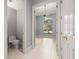 Hallway featuring tile flooring, bathroom, and view of a living room with a window at 713 Argyle Pl, Temple Terrace, FL 33617