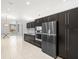 This is a kitchen with stainless steel appliances, dark cabinetry, and a tile floor at 713 Argyle Pl, Temple Terrace, FL 33617