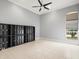 Bright living room features tile floors, a ceiling fan, a window, and custom built-in display shelving at 713 Argyle Pl, Temple Terrace, FL 33617