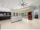 Open living room with tile flooring, windows, and island with white cabinets at 713 Argyle Pl, Temple Terrace, FL 33617