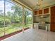 Screened-in patio with outdoor kitchen, grill, cabinets, and a scenic view of the water at 713 Argyle Pl, Temple Terrace, FL 33617
