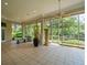 Spacious screened-in porch featuring tile floors, ceiling fans, and views of the lush surroundings at 713 Argyle Pl, Temple Terrace, FL 33617