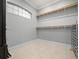 Empty walk-in closet with wood shelving, neutral walls, and tile floors at 713 Argyle Pl, Temple Terrace, FL 33617