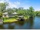Lakeside property with a private dock and screened lanai, set amidst a serene, tree-lined landscape at 713 Argyle Pl, Temple Terrace, FL 33617
