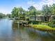 Waterfront home featuring a private boat dock and screened-in porch, surrounded by lush greenery at 713 Argyle Pl, Temple Terrace, FL 33617