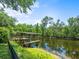 Waterfront property with a private dock surrounded by lush greenery, and waterfront views at 713 Argyle Pl, Temple Terrace, FL 33617