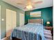 Bedroom with a wooden bed frame, ceiling fan, closet, and vibrant art piece at 809 Bahia Del Sol Dr # 72, Ruskin, FL 33570