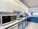 Modern kitchen features stainless steel appliances, blue backsplash, and white countertops and cabinets at 809 Bahia Del Sol Dr # 72, Ruskin, FL 33570