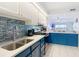 Renovated kitchen with modern appliances, blue cabinets, and view to living space at 809 Bahia Del Sol Dr # 72, Ruskin, FL 33570