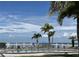 Outdoor community pool with palm trees overlooking ocean and skyline on the horizon at 809 Bahia Del Sol Dr # 72, Ruskin, FL 33570
