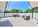 A covered patio has ample seating around a modern fire pit with paver flooring at 9027 Merrimoor Blvd, Seminole, FL 33777