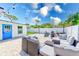 A beautifully staged back patio with modern furniture and a cozy fire pit area at 9027 Merrimoor Blvd, Seminole, FL 33777